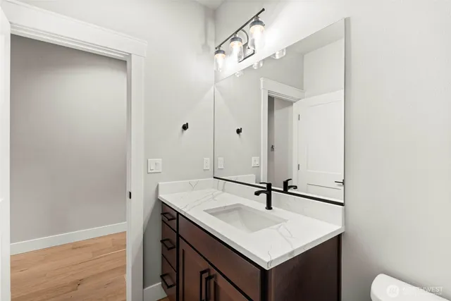 a bathroom with a sink a light fixture and a mirror