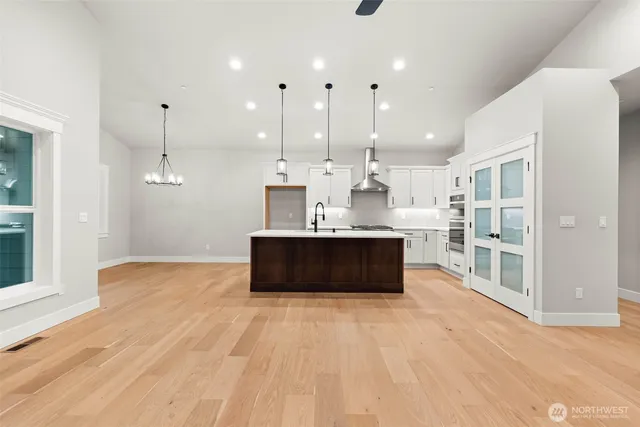 a large kitchen with stainless steel appliances kitchen island a large counter top and a wooden floors