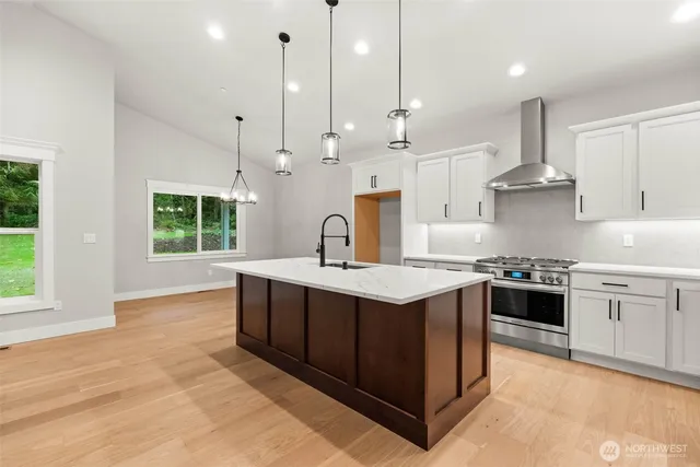 a kitchen with stainless steel appliances granite countertop a stove a sink and a refrigerator