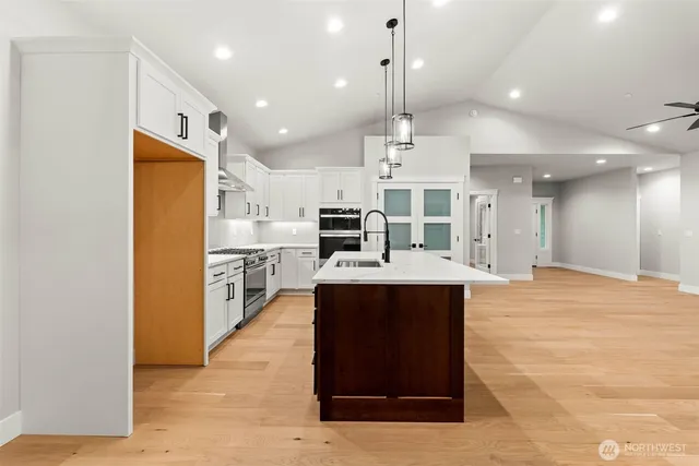 a view of kitchen with stainless steel appliances kitchen island a stove a sink a refrigerator and a counter top space