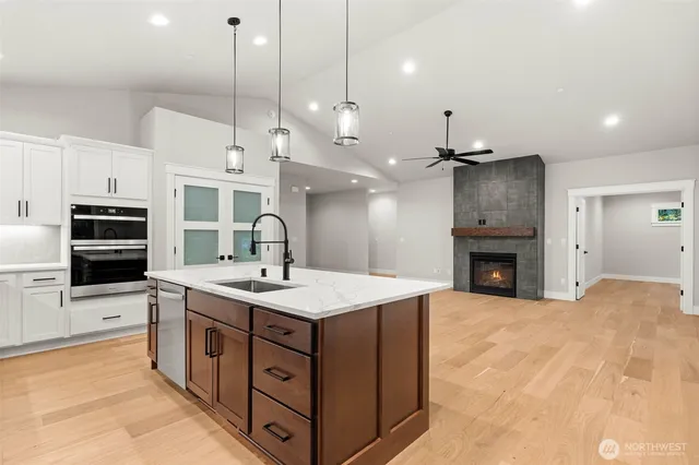 a large kitchen with kitchen island a sink stainless steel appliances and a chandelier