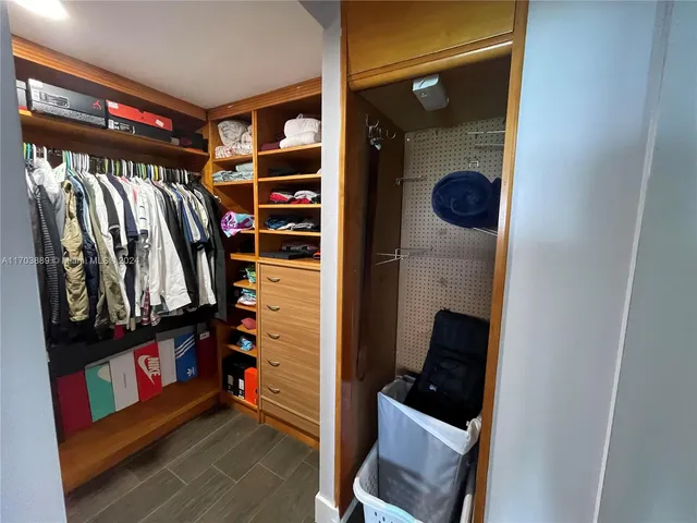 a view of walk in closet with clothes and shoes