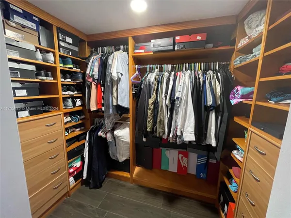 a view of walk in closet with clothes and shoes