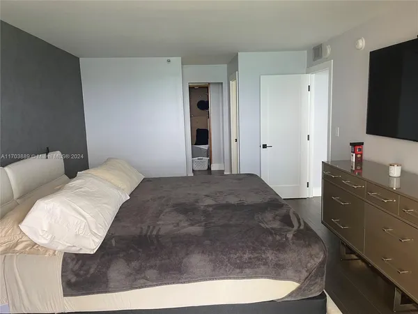 a bedroom with a bed and a flat screen tv