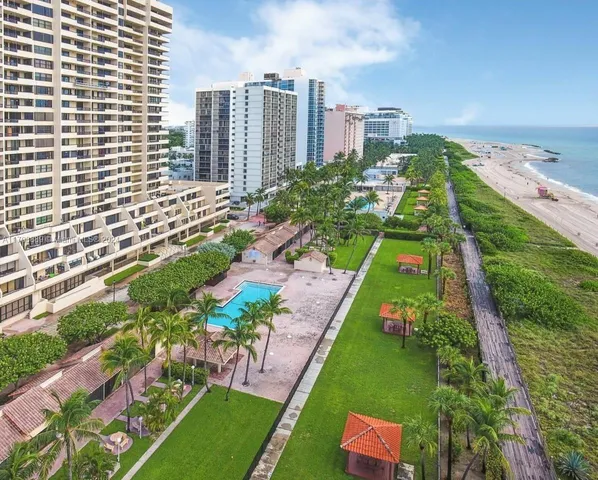 a living room with couches and kitchen view with wooden floor