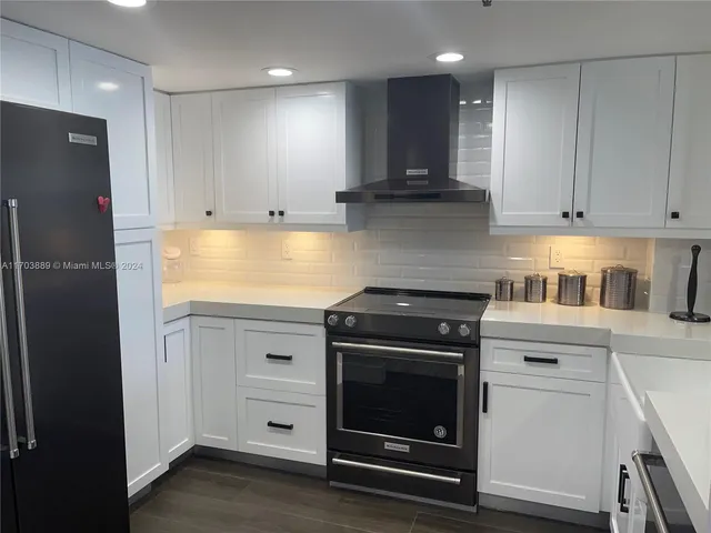 a kitchen with cabinets appliances and a wooden floor