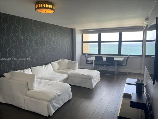 a living room with furniture and a floor to ceiling window