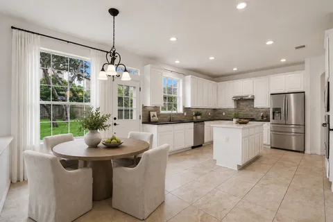 a kitchen with a refrigerator and white cabinets
