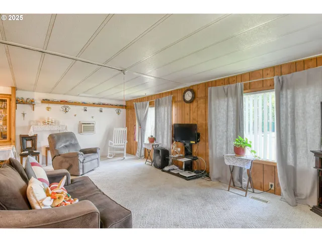 a living room with furniture a large window and a chandelier