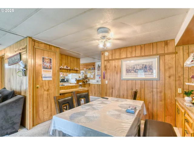 a kitchen with stainless steel appliances kitchen island granite countertop a refrigerator a stove and a sink with wooden cabinets