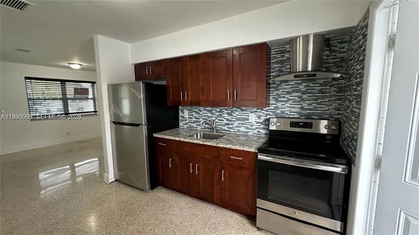 a kitchen with granite countertop stainless steel appliances and wooden cabinets