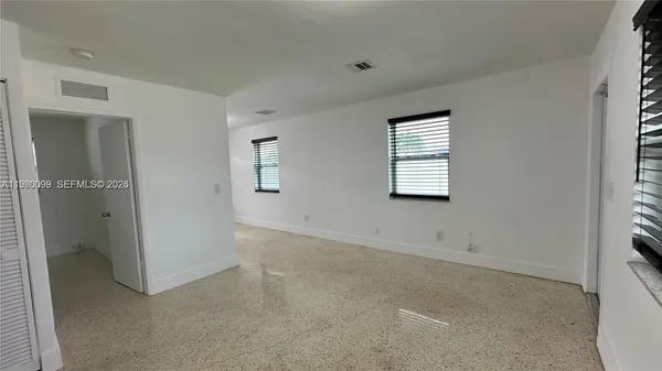 a view of a livingroom with an empty space and a window