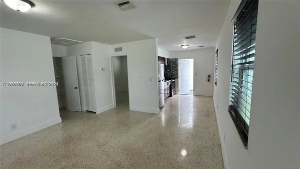 a view of hallway with furniture and a refrigerator