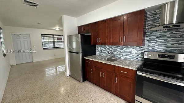 a kitchen with stainless steel appliances granite countertop a refrigerator and a stove top oven