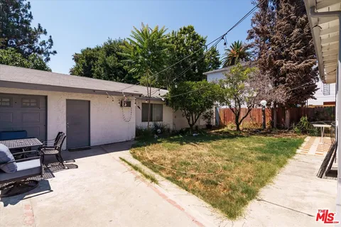 a backyard of a house with table and chairs