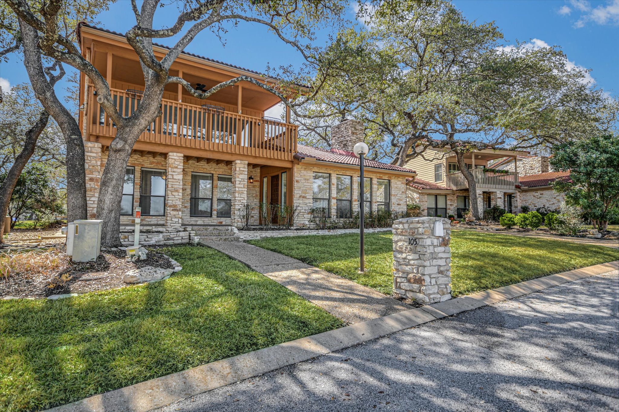 105 Crescent Bluff Austin, TX 78734 - Photo 2 of 28 a view of a white house with a yard table and chairs