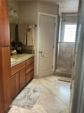 a bathroom with a granite countertop sink a mirror and a shower