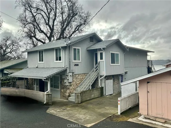 a view of a house with a yard balcony and stairs