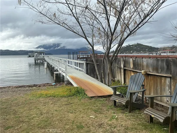 a view of an empty room with wooden floor and windows