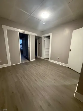 an empty room with wooden floor and entrance