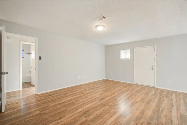 a view of empty room with wooden floor