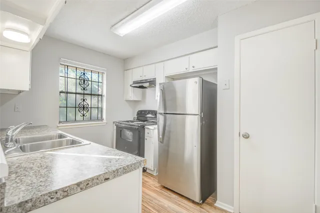 a kitchen with granite countertop a refrigerator and a sink