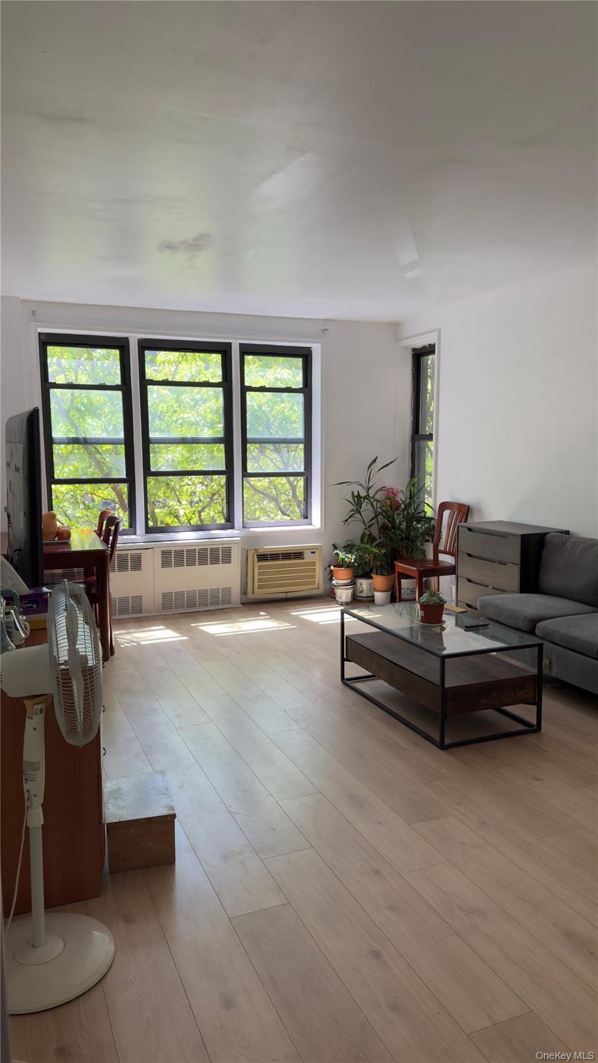 58-03 Calloway Street, Unit 4H Queens, NY 11368 - Photo 5 of 10 a living room with furniture and a large window