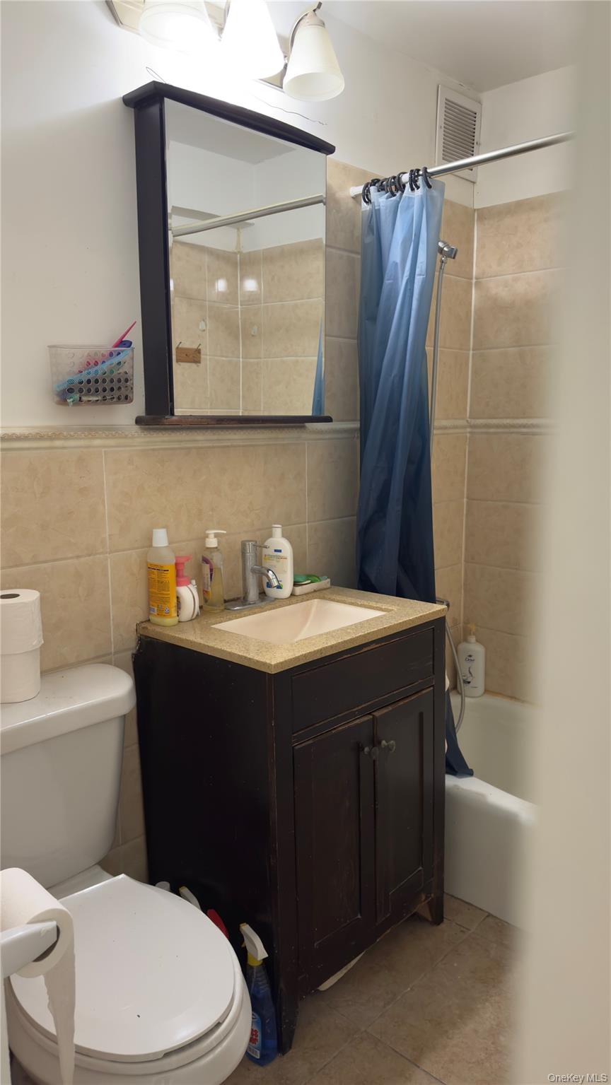 58-03 Calloway Street, Unit 4H Queens, NY 11368 - Photo 8 of 10 a bathroom with a sink vanity mirror and toilet