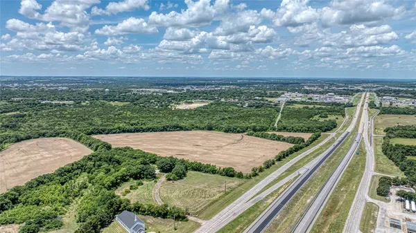 a view of a pathway both side of grassy field with shrub