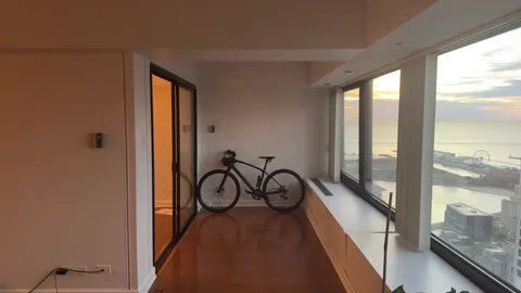 a view of a hallway with wooden floor and windows