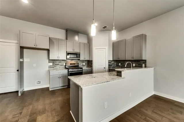 a kitchen with a refrigerator a stove top oven a sink and cabinets