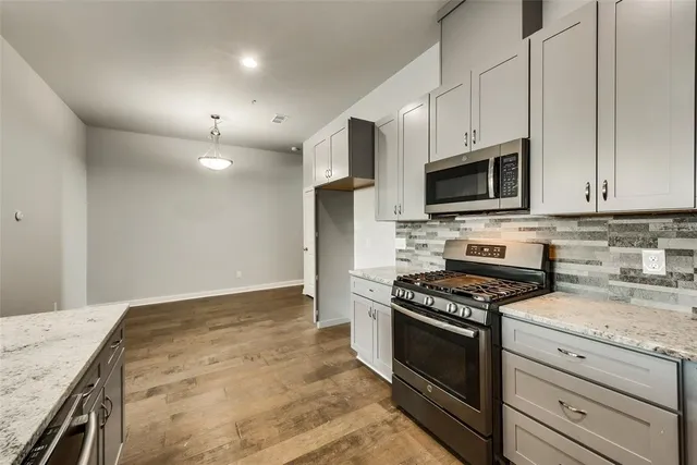 a kitchen with granite countertop a stove top oven and cabinets