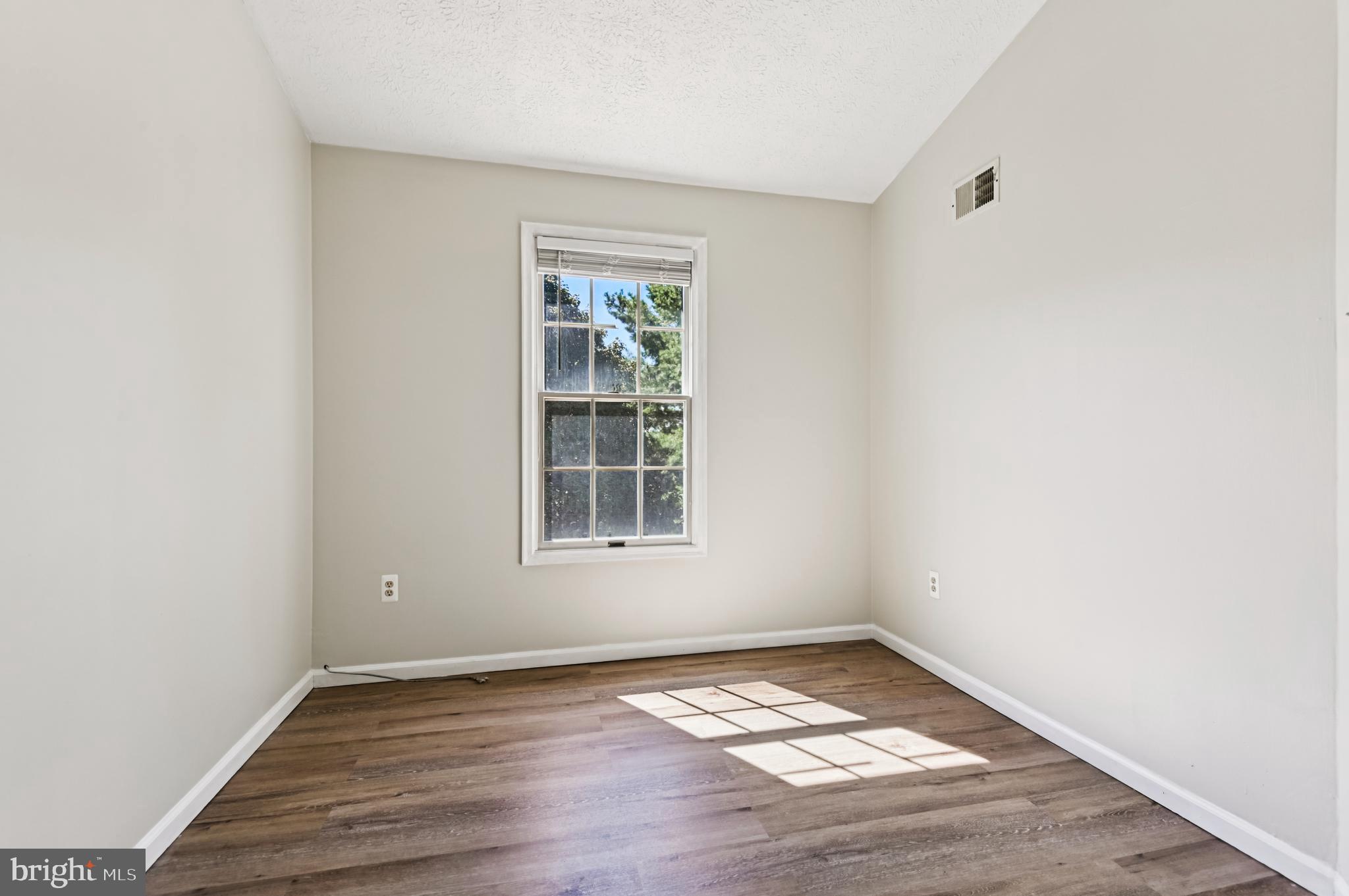 19 Championship Court, Unit K5 Owings Mills, MD 21117 - Photo 19 of 35 an empty room with wooden floor and windows