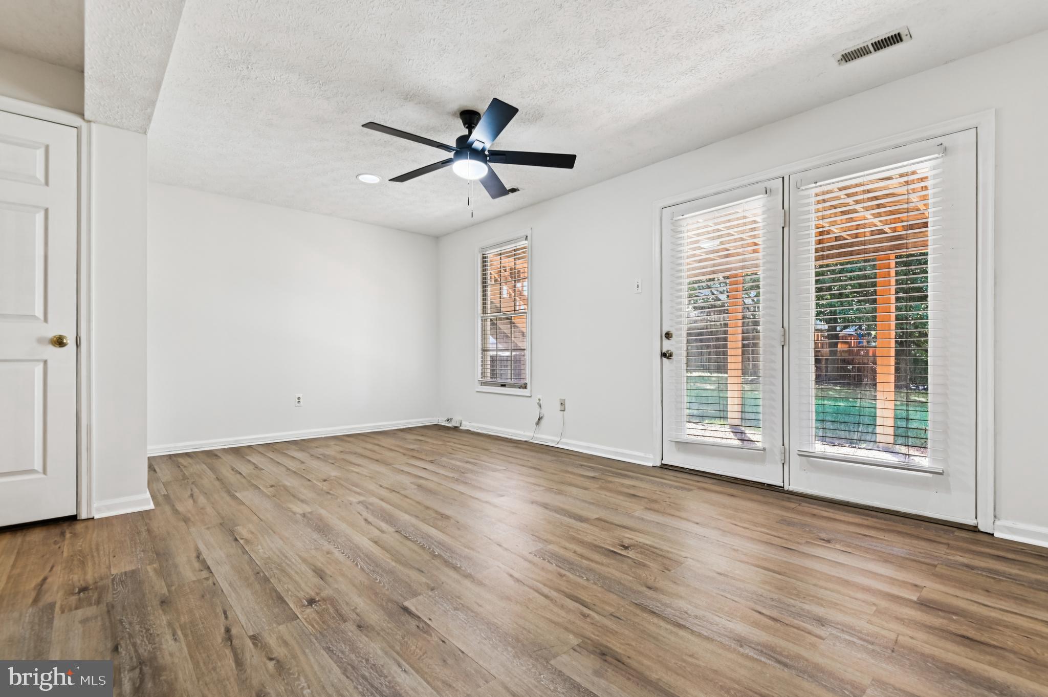 19 Championship Court, Unit K5 Owings Mills, MD 21117 - Photo 26 of 35 an empty room with wooden floor fan and windows