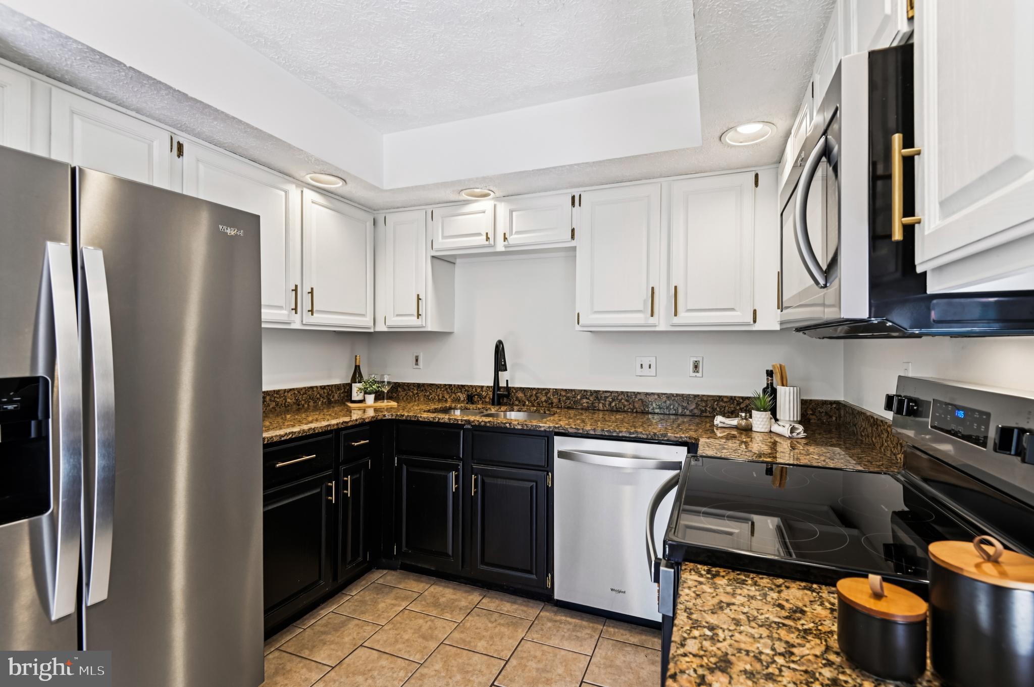 19 Championship Court, Unit K5 Owings Mills, MD 21117 - Photo 8 of 35 a kitchen with stainless steel appliances granite countertop a refrigerator a sink dishwasher a stove and white cabinets
