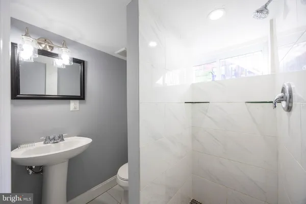 a bathroom with a sink a toilet and mirror