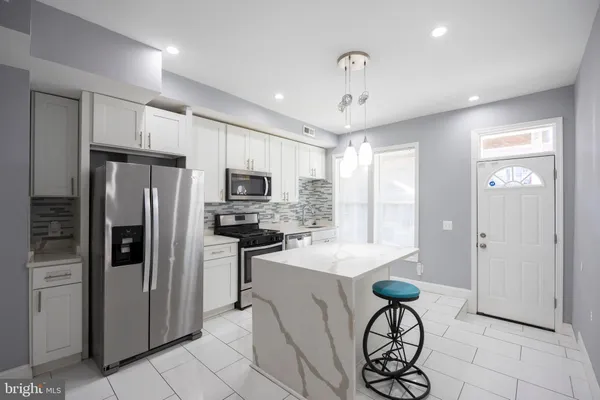 a kitchen with stainless steel appliances a refrigerator stove microwave and cabinets