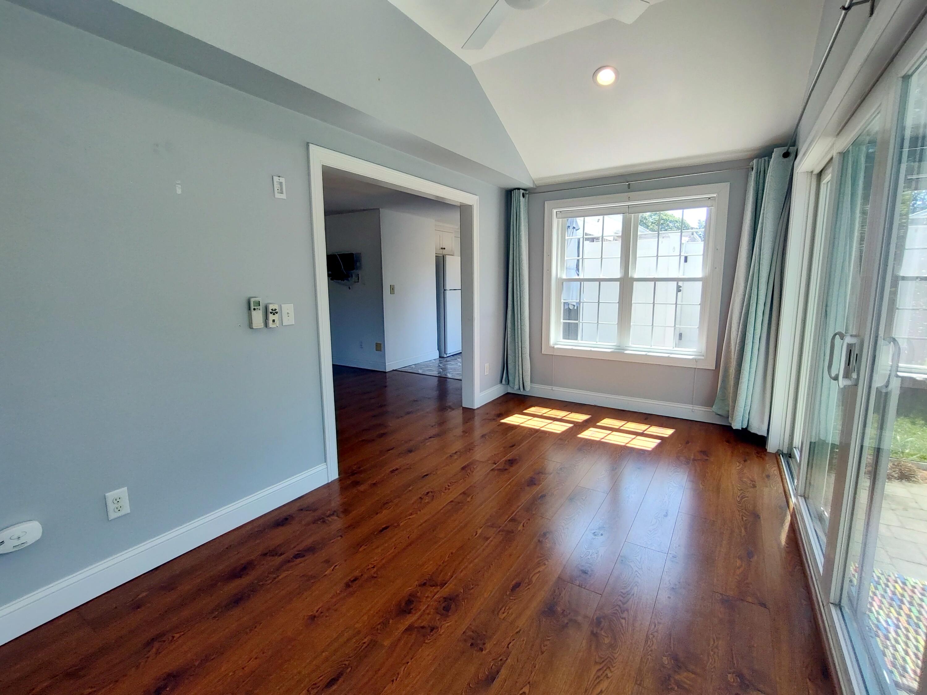 25 Mary-David Road, Unit 50A Yarmouth Port, MA 02675 - Photo 32 of 59 an empty room with wooden floor and windows with curtains