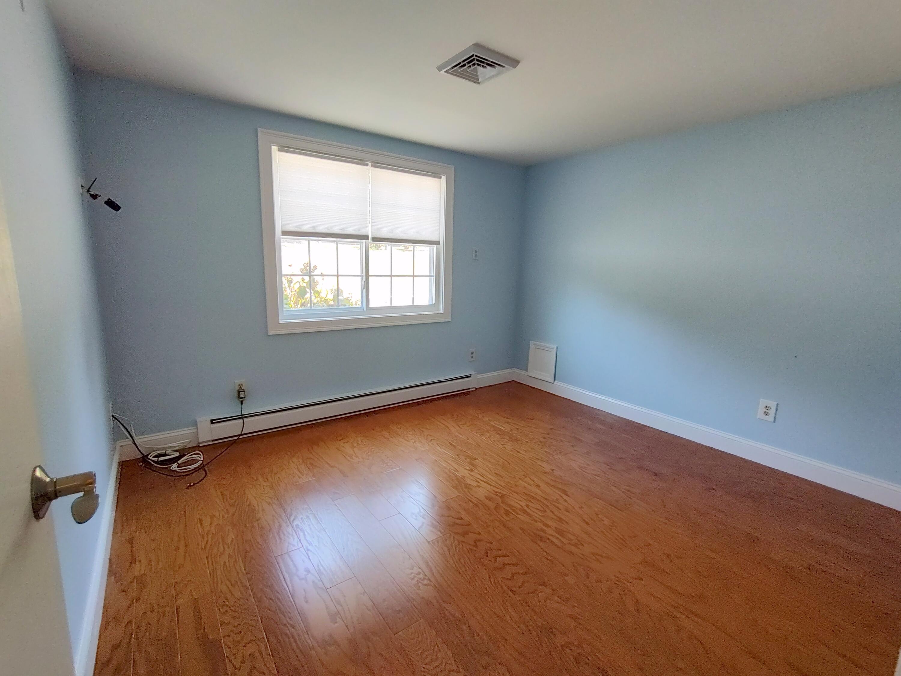 25 Mary-David Road, Unit 50A Yarmouth Port, MA 02675 - Photo 55 of 59 an empty room with wooden floor and windows