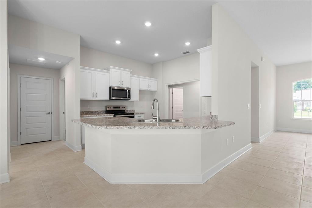 52 Undershire Path Palm Coast, FL 32164 - Photo 12 of 54 a kitchen with stainless steel appliances granite countertop a sink and a refrigerator
