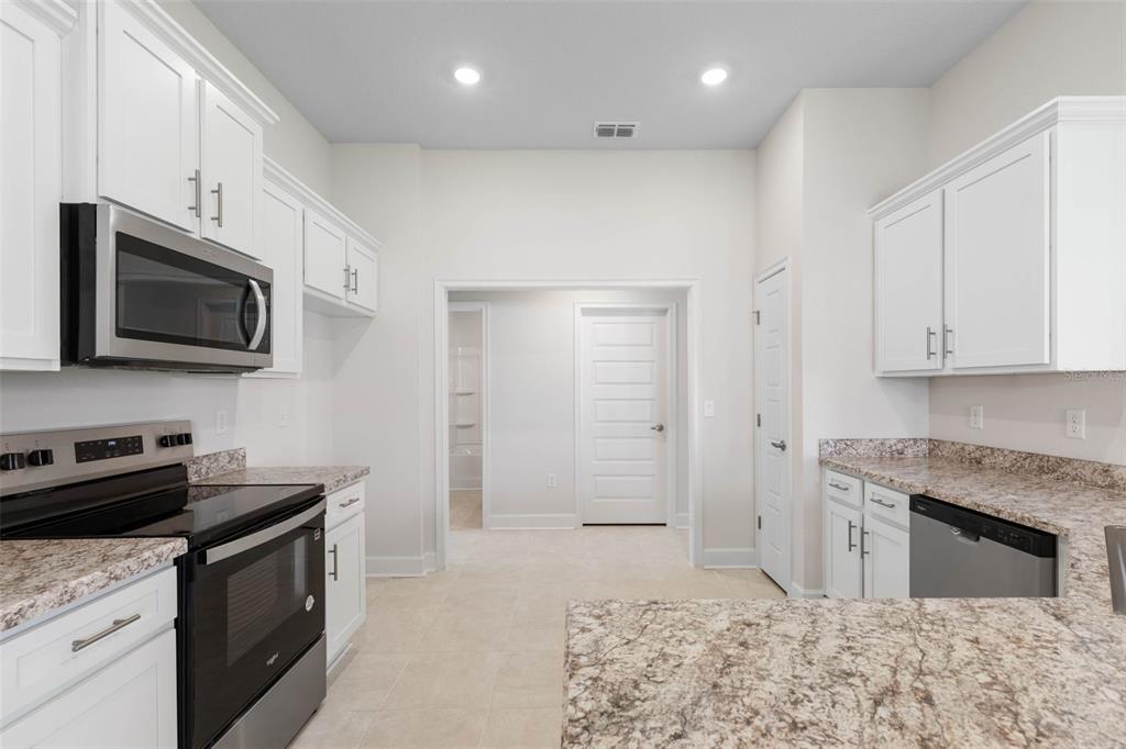 52 Undershire Path Palm Coast, FL 32164 - Photo 14 of 54 a kitchen with stainless steel appliances granite countertop a stove a sink and a microwave