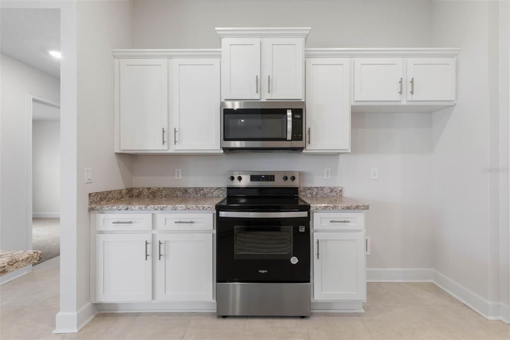 52 Undershire Path Palm Coast, FL 32164 - Photo 18 of 54 a kitchen with stainless steel appliances granite countertop a stove and a microwave