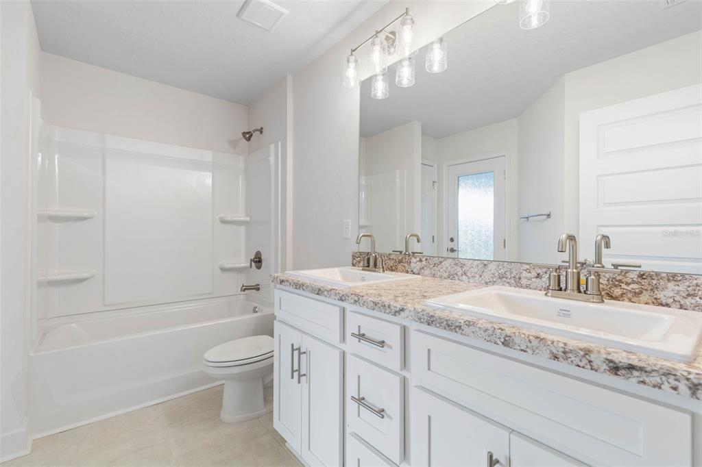 52 Undershire Path Palm Coast, FL 32164 - Photo 34 of 54 a bathroom with a granite countertop sink a toilet and bathtub