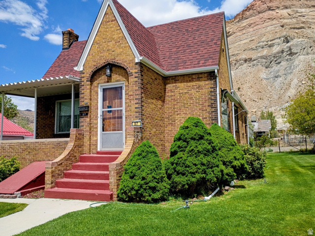 57 C Street Helper, UT 84526 - Photo 4 of 62 Brick exterior featuring a red shingle roof and a covered porch