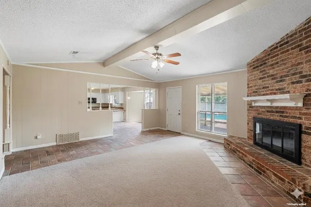 a view of a livingroom with an empty space and a fireplace