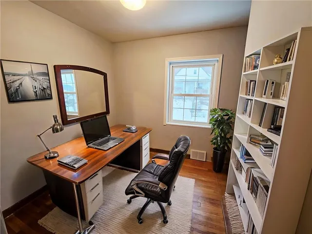 a view of a workspace with furniture and a bookshelf