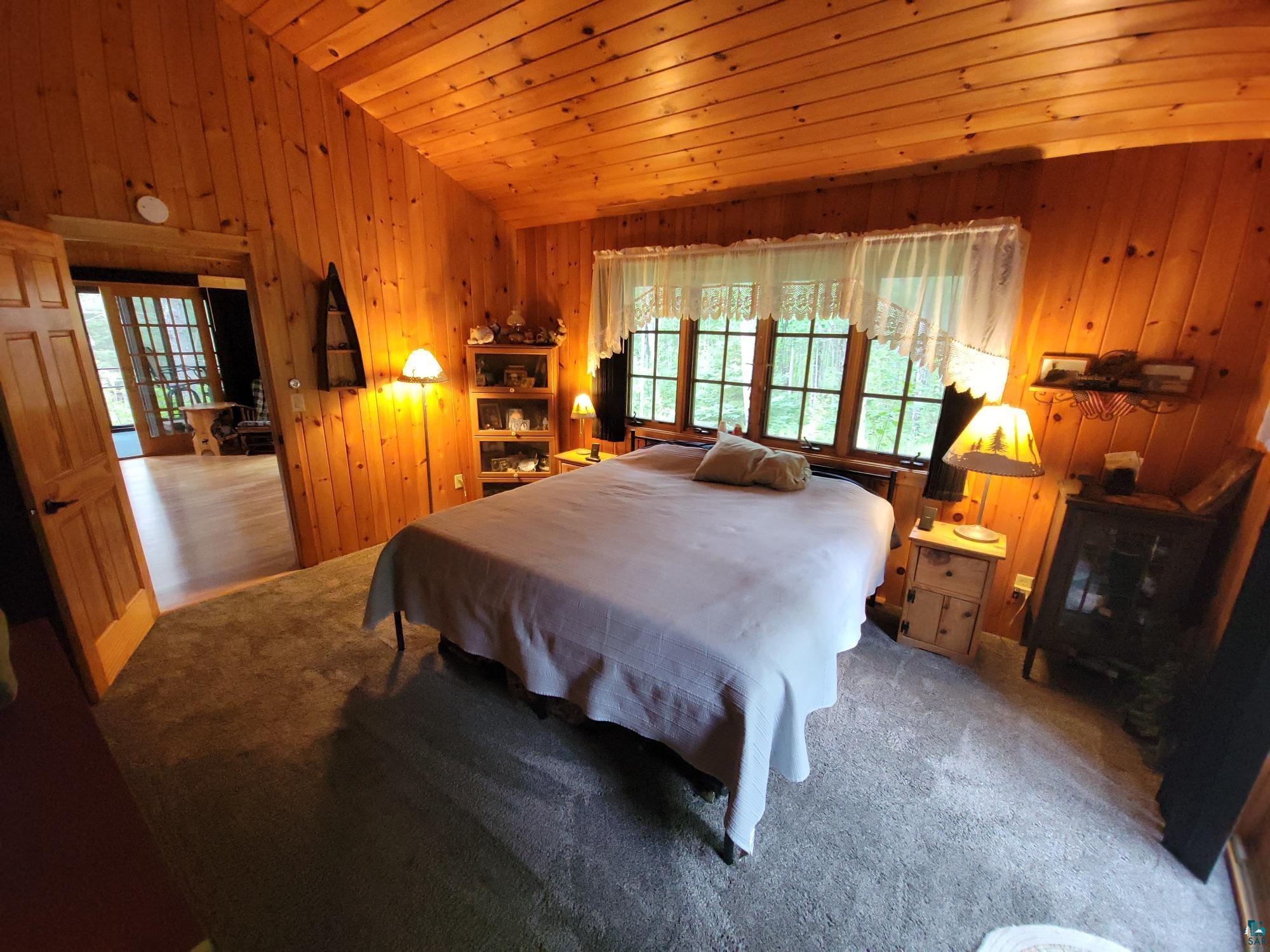 181 Linnell Road Grand Marais, MN 55604 - Photo 47 of 77 Wood paneling throughout, wood-finish ceiling, and natural light from multiple windows