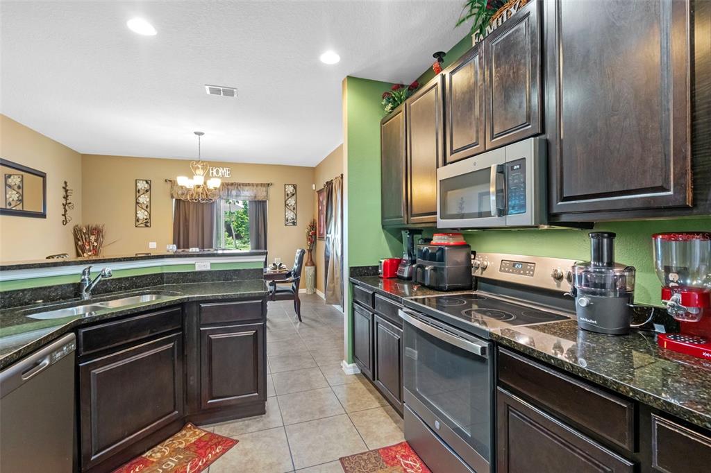 3509 Spring Creek Road Dundee, FL 33838 - Photo 11 of 32 a kitchen with stainless steel appliances granite countertop a sink and stove