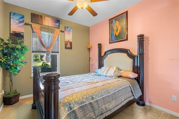 a bedroom with a bed dresser and a potted plant