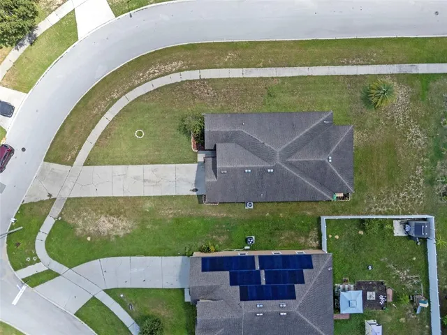 an aerial view of a house with a yard